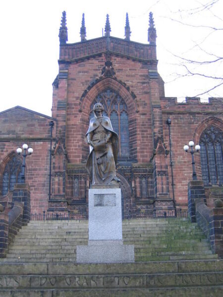 Metal statue of a lady in front of a church